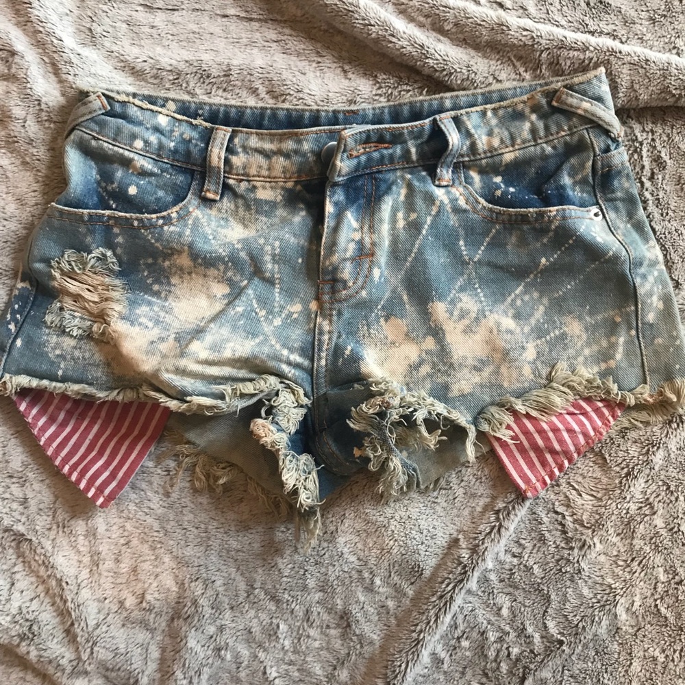 Distressed denim shorts with paint splatter